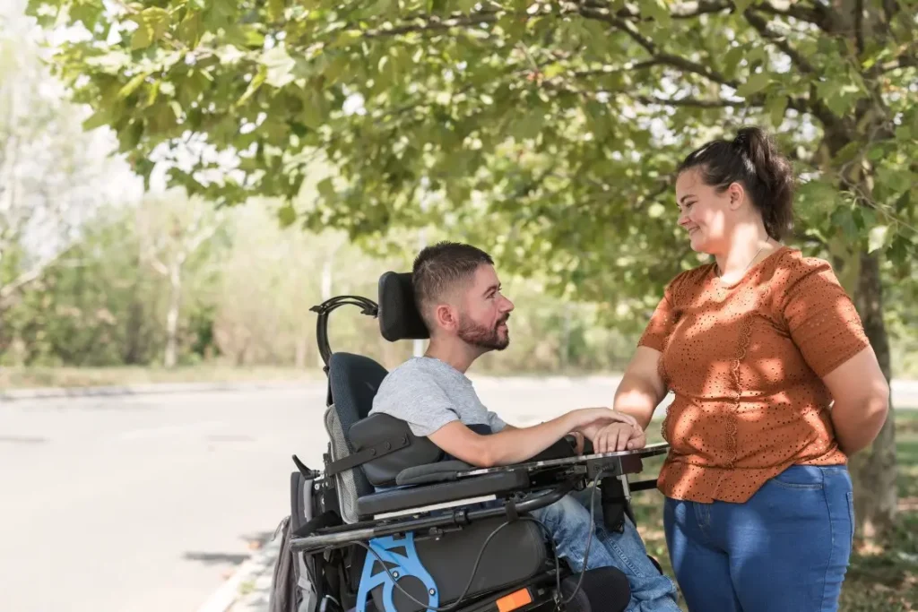 Disabled man in wheelchair smiling with support worker
