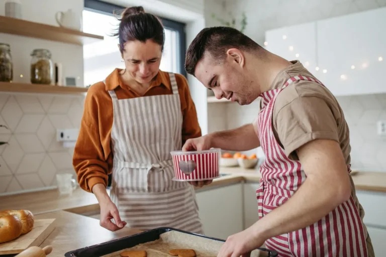 Disabled man baking in kitchen with support worker