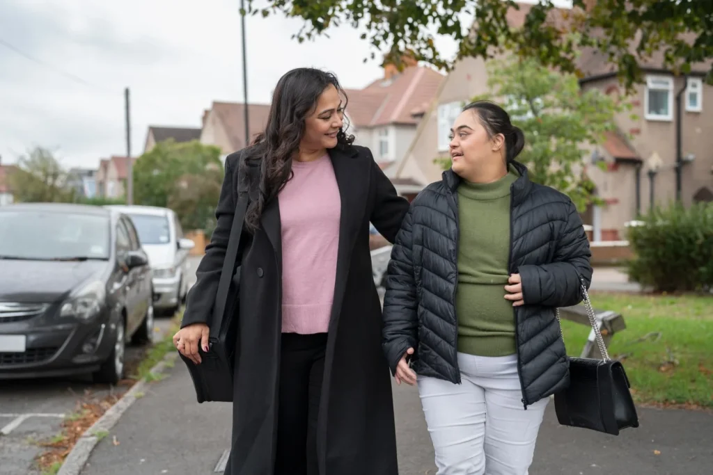 Indian girl with down syndrome walking down the road with mother