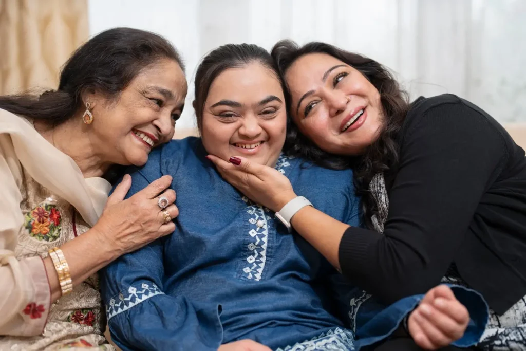 Indian girl with down syndrome laughing with two family members