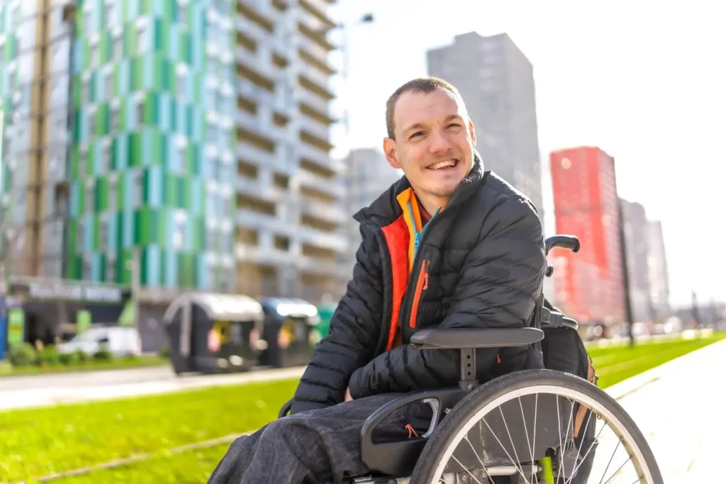 Happy disabled man in wheelchair smiling at the camera