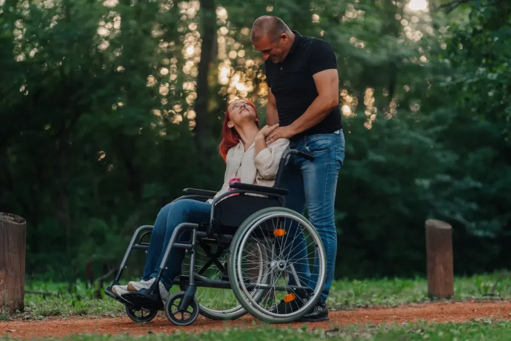 Disabled woman in wheelchair looking up at her friend