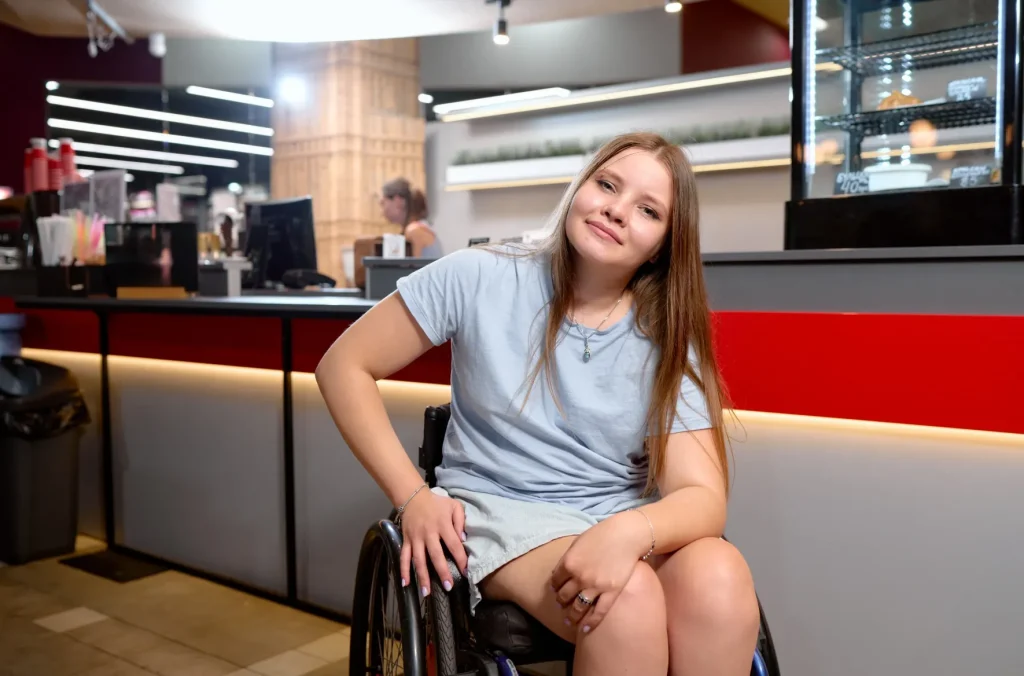 Happy disabled woman in wheelchair smiling at camera